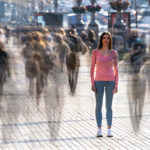 Eine Frau die mitten in einer Menschenmenge steht und sich dennoch einsam und allein fühlt.