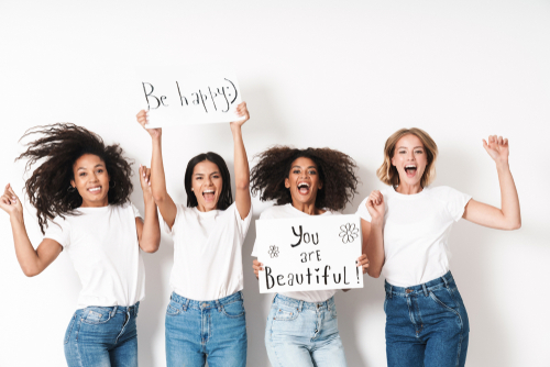 4 glückliche Frauen halten Plakate, auf denen steht - be happy und you are beautiful