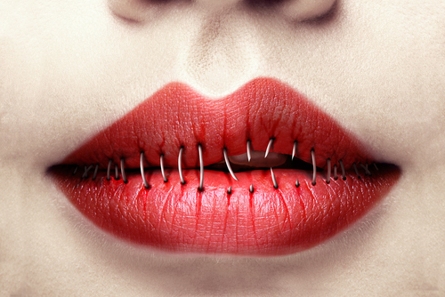 Zugenähte rote Lippen, die auf einer Seite aufbrechen.